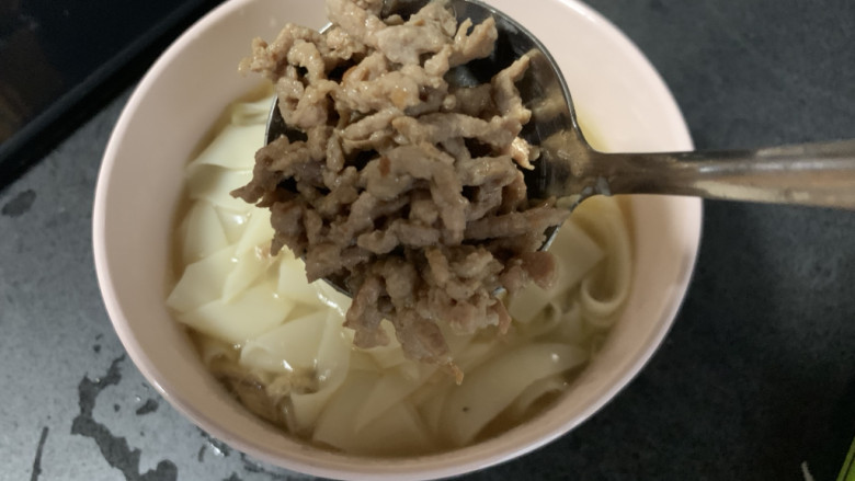 肉丝刀削面,煮好的面盛入碗中,浇上肉丝