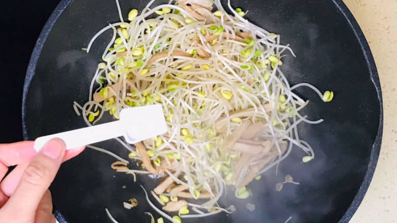 豆芽炒肉丝,翻炒至豆芽恹恹,撒入盐调味