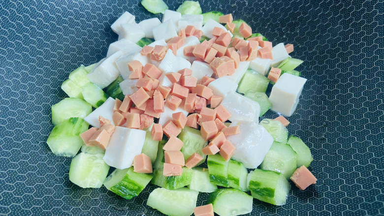 黄瓜烧豆腐,放入黄瓜和火腿丁翻炒一下,再放入豆腐
