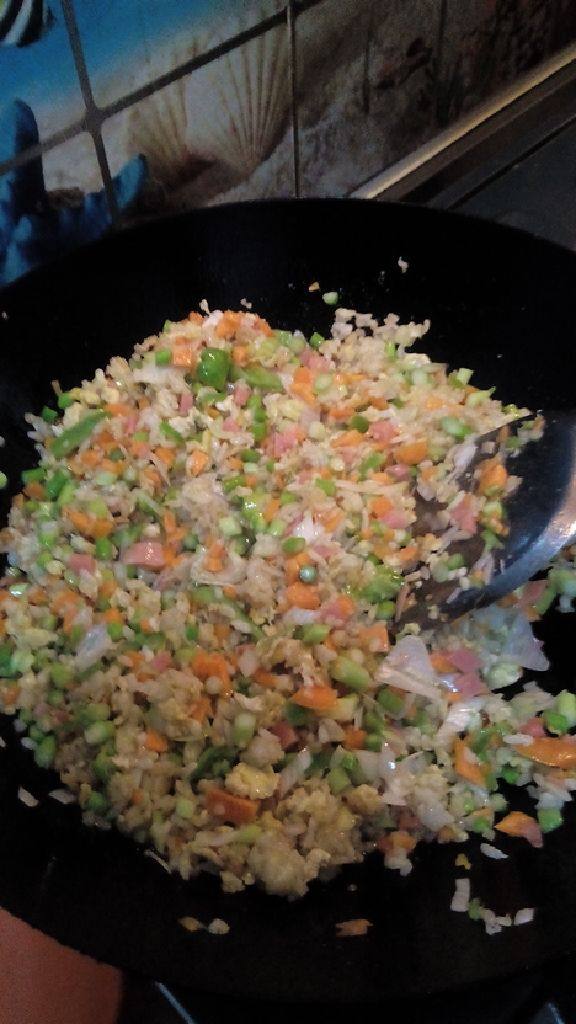 扬州火腿蛋炒饭,加入适量十三香,盐,然后把切成块的胡萝卜等一起下锅,不停翻炒,直到有了很浓的香味,大概三分钟就可以出锅啦