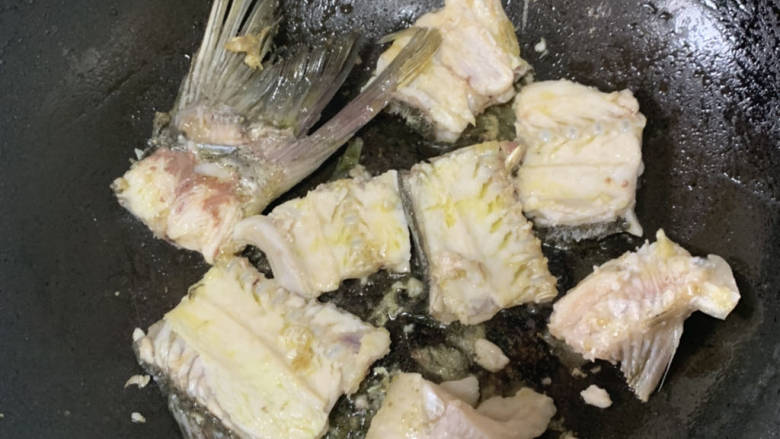 川味家常酸菜鱼,准备一盆开水,起锅放一点点的油,鱼骨下锅两面煎到稍微变色,鱼骨煎烂也没关系
