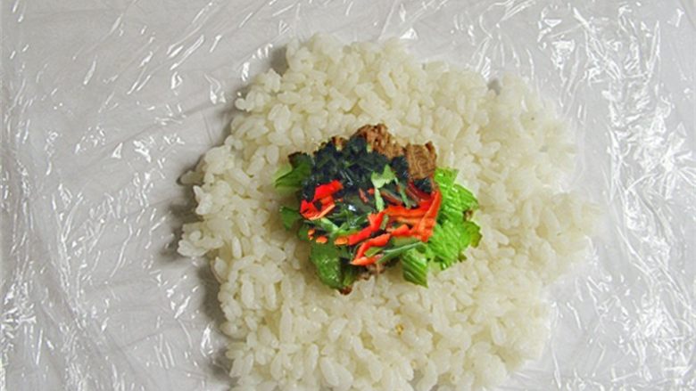 可爱的企鹅饭团,在双层保鲜膜上铺好<a style='color:red;display:inline-block;' href='/shicai/ 507'>米饭</a>放上家常菜做馅儿,不要放得太多,饭团不容易团起来