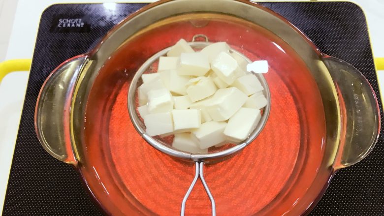 宝宝辅食:南瓜豆腐虾皮煲-8M+,蒸南瓜的同时,将内脂豆腐划成小块,放在筛网中,放入沸水中焯水下,这一步也可以省略哈,有些宝宝不喜欢豆腐的生味儿,焯水下会更好些。