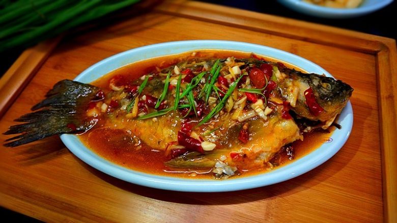 家常烧鲫鱼,将调好的料稠汁儿浇在鱼身上面,撒上葱叶即可