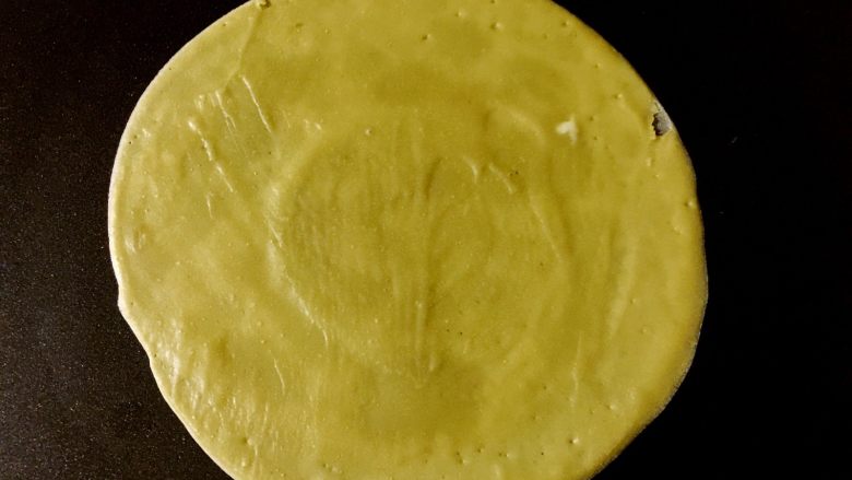 抹茶奥利奥千层蛋糕,不粘平底锅加热,倒入适量(大概2汤勺)面糊,用摊煎饼的工具摊成较薄的面皮。