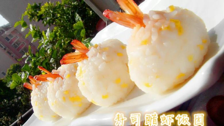 寿司醋饭团,在保鲜膜上放一大勺饭摊平摊圆。放入一个虾仁。留尾部在外。在缩紧保鲜袋把饭团捏紧成团。