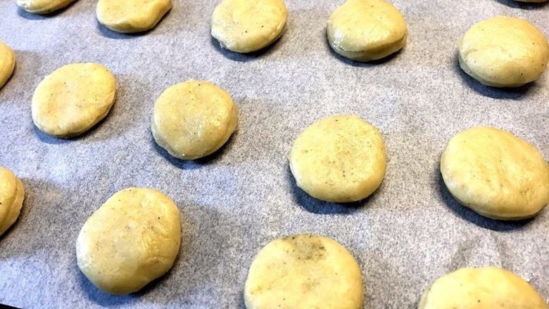 迷你黑芝麻司康,烤箱铺好饼干纸,将迷你司康有秩序的摆放好;