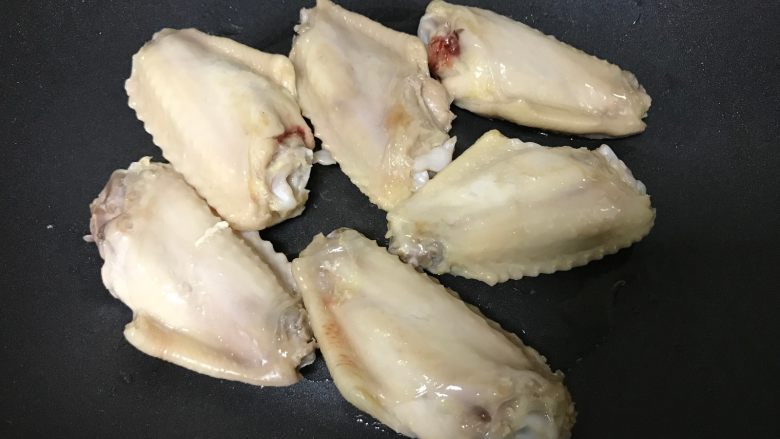 红烧鸡翅,捞出鸡翅淋干水分。锅内少油放入鸡翅,皮朝下煎至金黄。