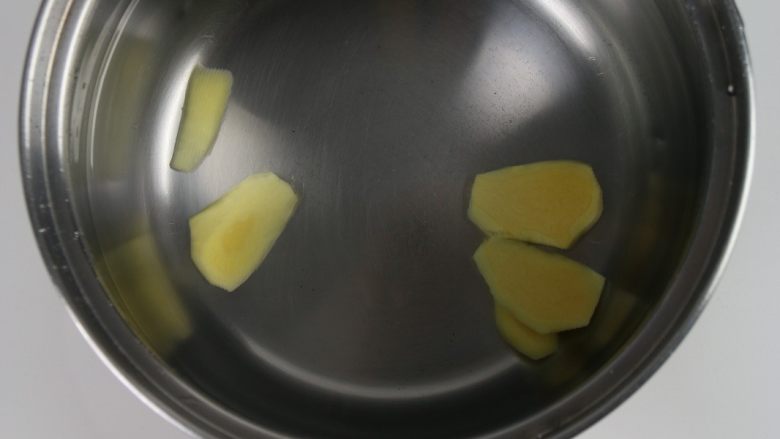 排骨板栗香焖饭,锅里倒入适量的水,加入姜片。