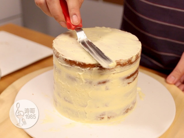 瑞士奶油霜 - 彩虹抹面蛋糕,15、然后用小抹刀把每层填充突出来的奶油霜均匀抹在整个蛋糕的表面,使蛋糕的表面覆盖上一层薄薄的奶油霜,这么做是为了固定蛋糕表面的蛋糕渣