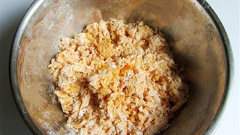 维尼豆沙馒头,不要急忙下手,先用筷子把四周的面粉往中间坑里填,然后转圈搅拌,不要把水碰到盆边上,搅成絮状,再用拌面刮刀把盆边刮干净