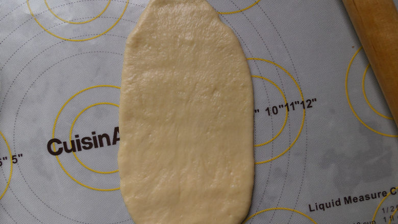 鲜奶雪路面包,静置好后 我们取一个面团排气 然后擀成一个长片