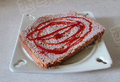 巧克力奶吐司煎蛋 ,将另一片吐司放入盘中,挤上<a style='color:red;display:inline-block;' href='/shicai/ 753'>番茄沙司</a>