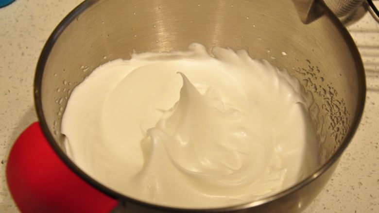 日式豆乳盒子蛋糕,砂糖分3次加入到蛋白中,蛋白打至湿性9分发的状态(如图,提起打蛋头会呈现小弯钩)。