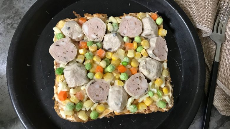 牛肉丸吐司披萨,再摆上各种蔬菜粒(我用的是胡萝卜粒、豌豆粒、玉米粒)。