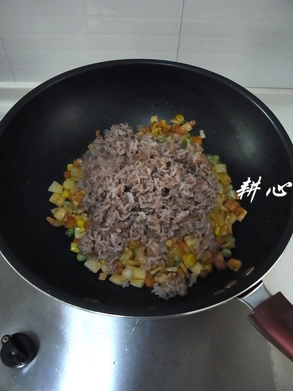 红米炒饭,放入红米饭,煸炒均匀。