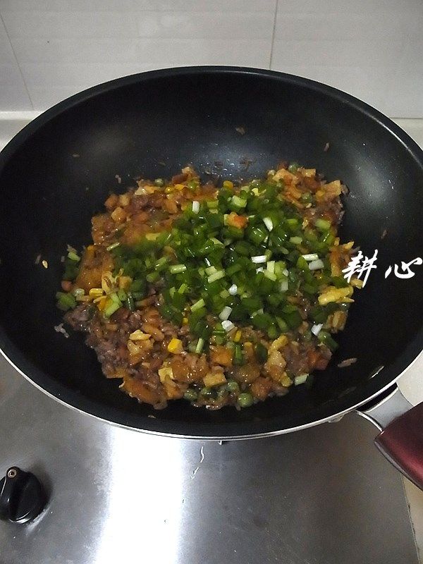 红米炒饭,放入葱粒,炒匀。