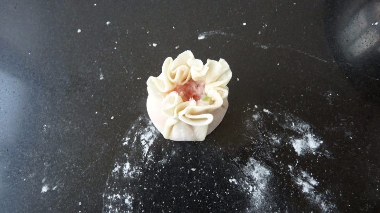 菊花烧卖,把饺子皮用手往里稍收,顶部的皮不收紧,作打开状