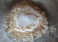黄油小餐包,面粉放入钢盆,中间挖一个小坑,中间放糖和盐,周圈撒上速发酵母