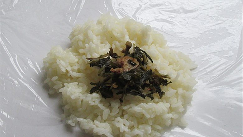 猫鱼便当,米饭摊在保鲜膜上,中心放上自己喜爱吃的菜做馅料即可,榨菜、肉松都可以