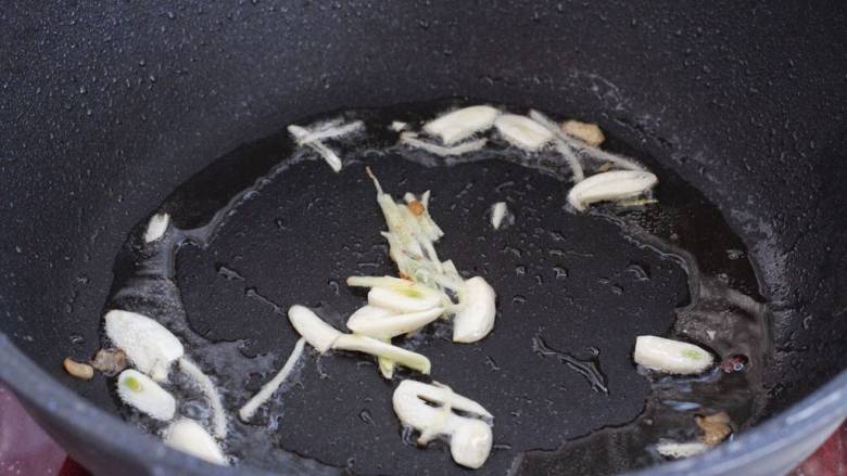 芹菜木耳炒肉丝,就锅中底油放入蒜片和姜丝,小火炒出香味。