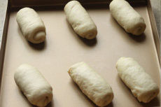 培根芝士卷,用利刀在面团中间位置划口，放温暖湿润处进行二次发酵