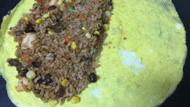 黄金蛋包饭,翻面关火,一半铺上炒好的米饭。