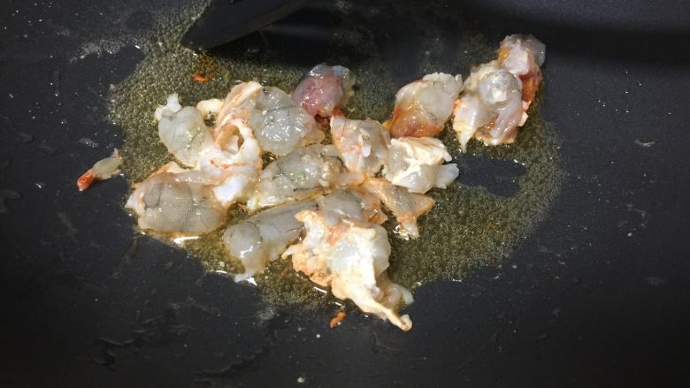 黄金蛋包饭,锅内加适量油,烧至六成热时放入虾块儿炒至变色。