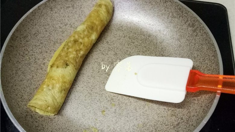 香椿厚蛋烧,蛋液即将凝固时,借用刮刀将蛋饼从一头卷至另一头;