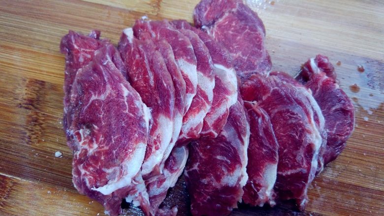 麻辣水煮牛肉,将<a style='color:red;display:inline-block;' href='/shicai/ 7036'>牛里脊肉</a>稍微解冻,切2厘米左右的片,注意切的方向和厚度。切好后用刀背拍一下,让纤维松散一些。