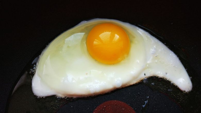 韩式酸辣鱿鱼盖饭,热锅热油,将<a style='color:red;display:inline-block;' href='/shicai/ 9'>鸡蛋</a>打入平底不粘锅,煎至七八成熟,就是底部凝固,边缘有焦痕,蛋黄表面薄薄一层稍有流动的样子