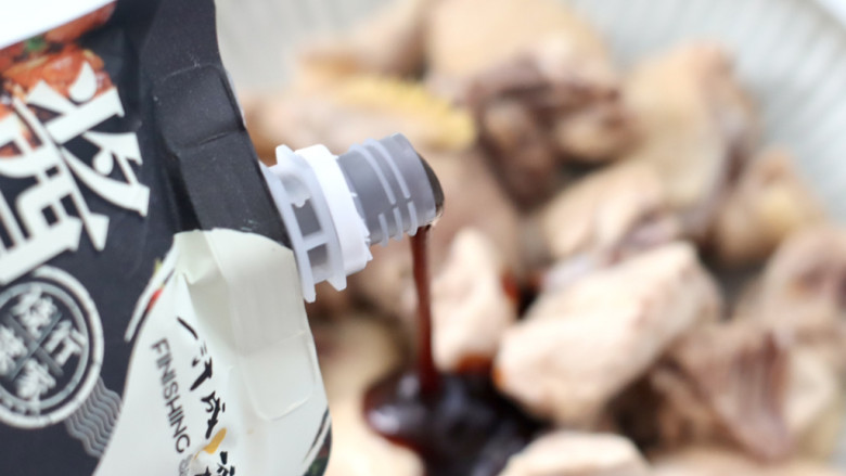 酱香土豆鸡,鸡块洗净沥干水分放入容器里,先倒入50克酱香烧汁。