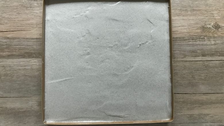 黑米戚风蛋糕卷,将混合好的面糊倒入盘内,用刮平稍加刮平,震两下模。