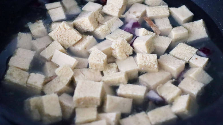 冻豆腐鱿鱼煲,锅中倒入适量的清水,放入冻豆腐。