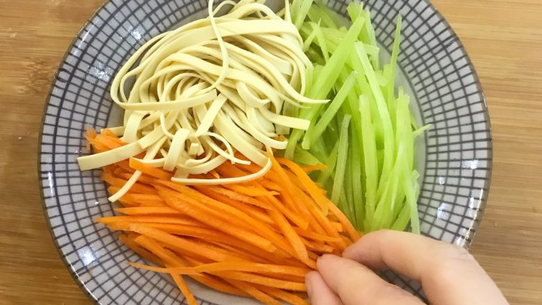 宝宝辅食:蒸素三丝-24M+,拿一个碗,底部放一些香菇,然后把莴笋丝、胡萝卜丝、千张丝沿着碗壁依次摆放,用手按紧一点哈。