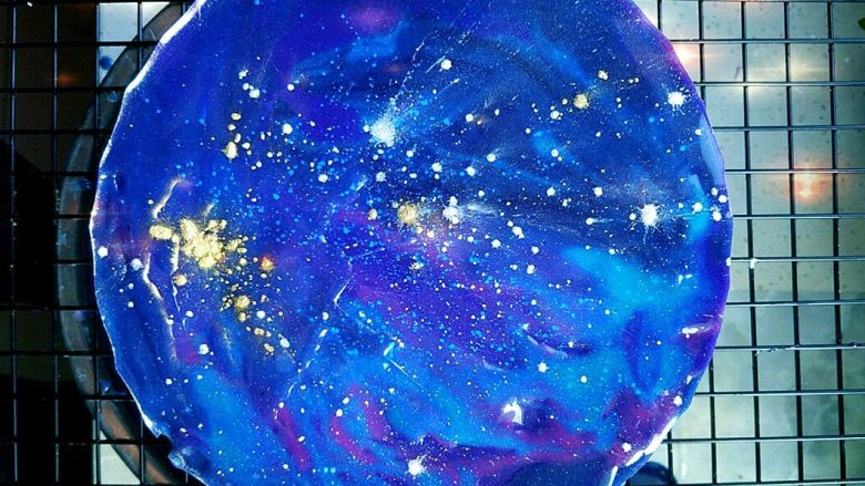 星空酸奶慕斯蛋糕,再一次淋上其他颜色后,用刮刀快速抹一下表面。凝固后在表面撒少许闪粉即可