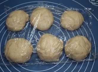 培根沙拉面包,将发酵好的面团分成六份,再滚圆,盖上保鲜膜松弛十分钟