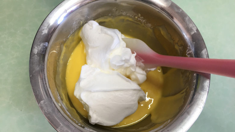 水果盒子蛋糕,这时打开烤箱预热,温度为170度,取1/3蛋白霜放入蛋黄液中。