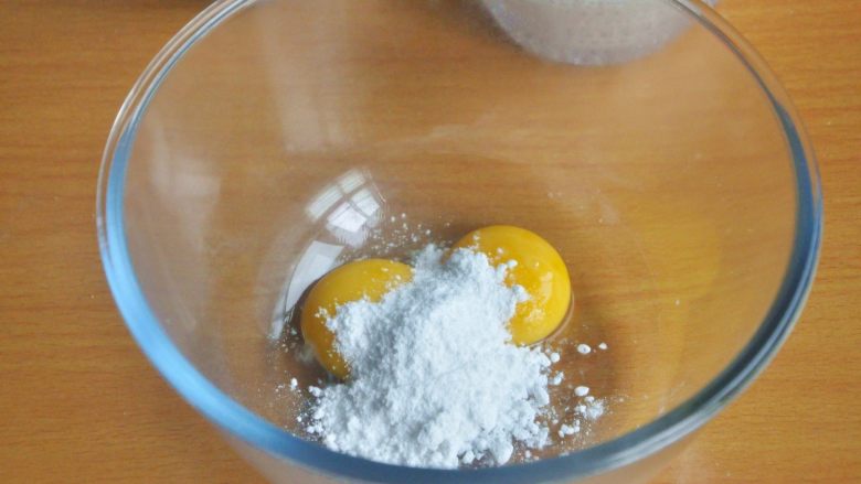 原味松饼(无泡打粉版),在装有蛋黄的打蛋盆中倒入糖粉。