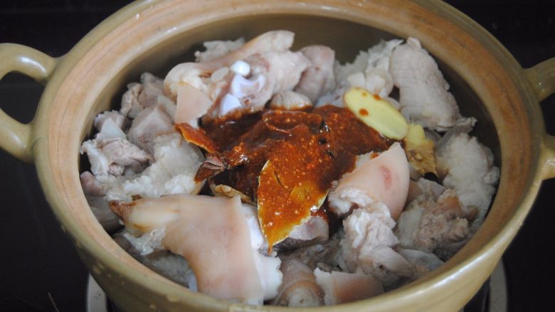 南乳猪蹄,把调好的酱汁倒入锅内,加入姜片拌匀
