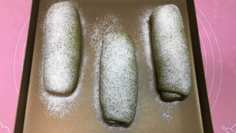 抹茶凤梨全麦面包,30分钟左右面包发酵完成,取出后在面包表面筛一层干粉。