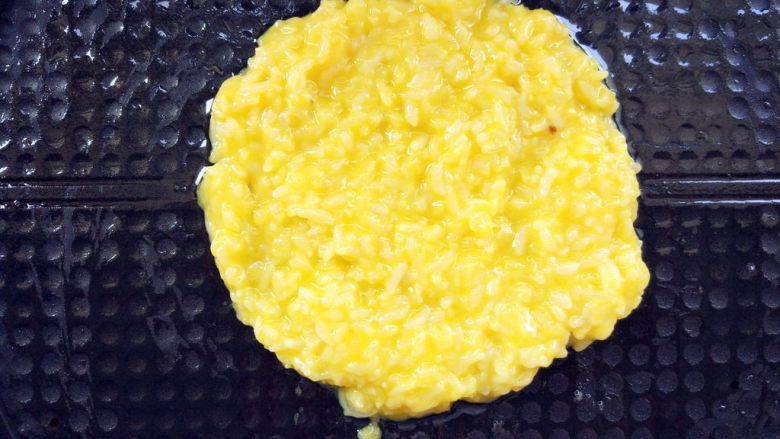 创意南瓜米饭煎蛋饼,电饼铛预热,刷油,挖一块儿用锅铲摊平,将底部烙脆