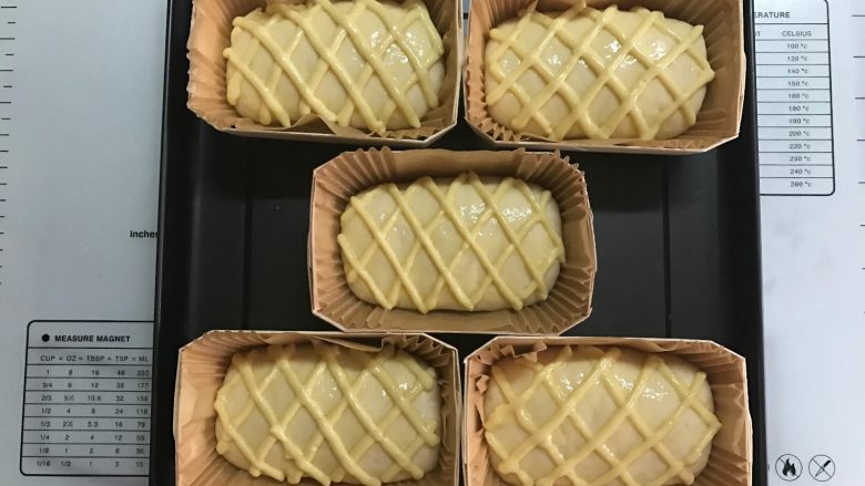 黄桃香酥面包,表面刷蛋液,卡仕达酱挤成菱形状。