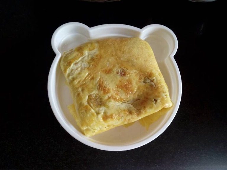 蛋包饭,鸡蛋皮刚好全熟，关火，用木铲或者盛饭勺将鸡蛋皮翻上来把饭包住，最后形成一个正方形，如图，大功告成