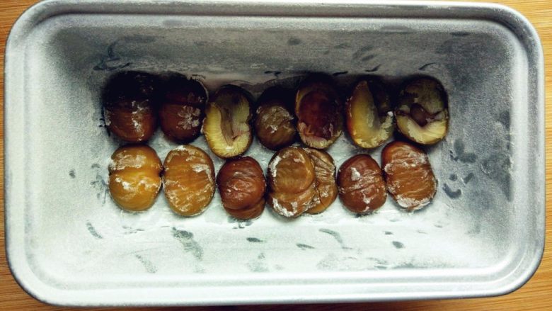 黑糖栗子磅蛋糕,模具内层涂少许黄油(分量外),撒少许面粉,掸掉多余的面粉,将栗子仁摆在底部