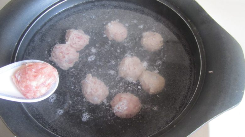 瓠子粉丝汆丸汤,用勺将挤好的丸子放入锅中水中煮, 注意不用等到水开后再下锅, 温水就可以放入丸子了;