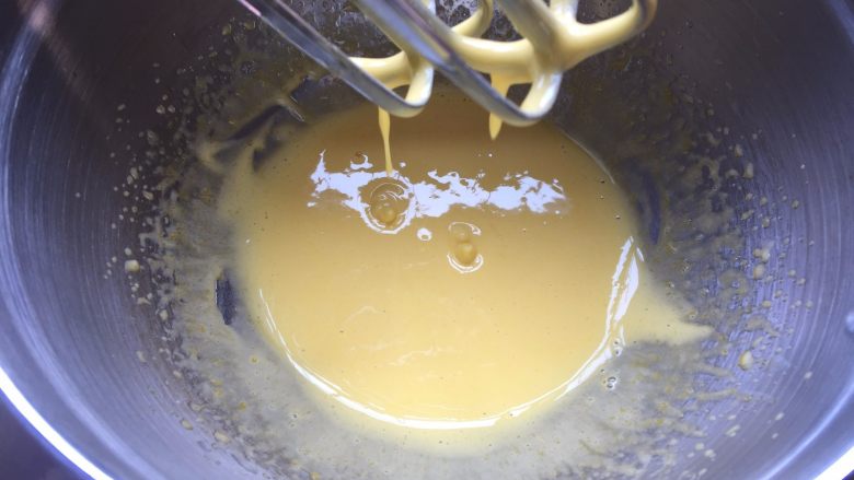 棉花奶油杯子蛋糕,用电动打蛋器打发蛋黄液至浓稠状态,提起打蛋头蛋液缓慢滴落