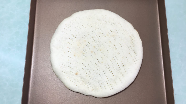 美味的牛排披萨,两个都做好后取一个烤好的披萨皮,放在烤盘里。