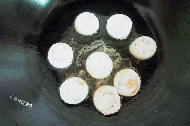 金钱蛋,锅中放适量油,油热后将鸡蛋轻轻推进去,中火炸制,一面炸好后再轻轻翻面。