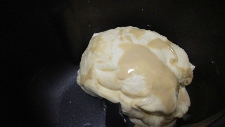 酸奶软欧,取出冷藏的面团,抹上融化的酵母;